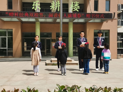 1捐赠仪式上郑州市第六初级中学学生代表为人和路小学学生赠书